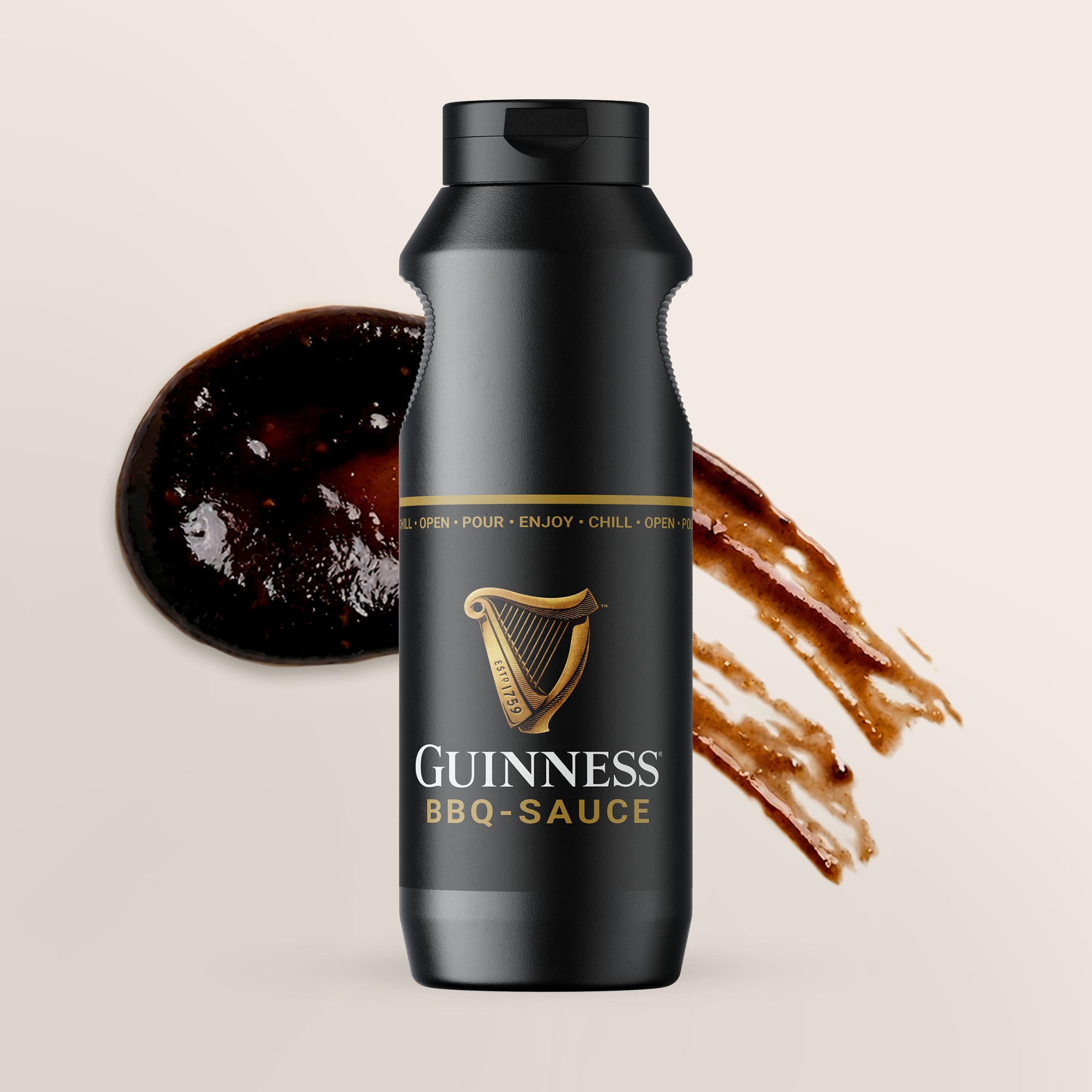 Schwarze Flasche Guinness BBQ-Sauce mit gespritzter Soße auf beigem Hintergrund.