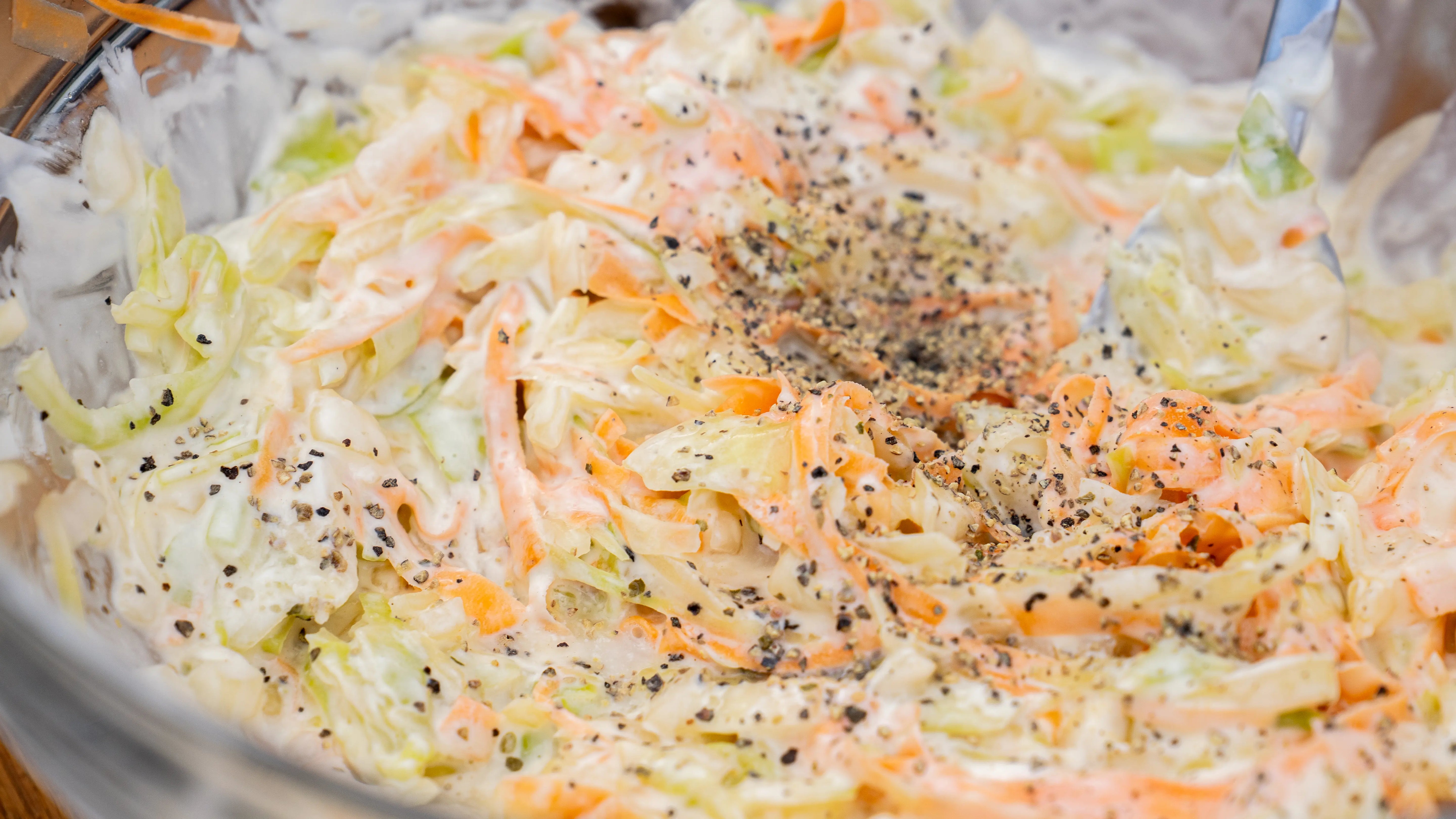 Nahaufnahme eines cremigen Krautsalats mit Pfeffer.