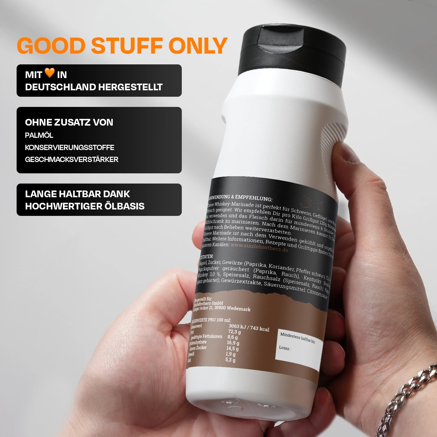 Weiße Gewürzflasche mit schwarzem Deckel, gehalten von einer Hand. Text: Mit Herz in Deutschland hergestellt.