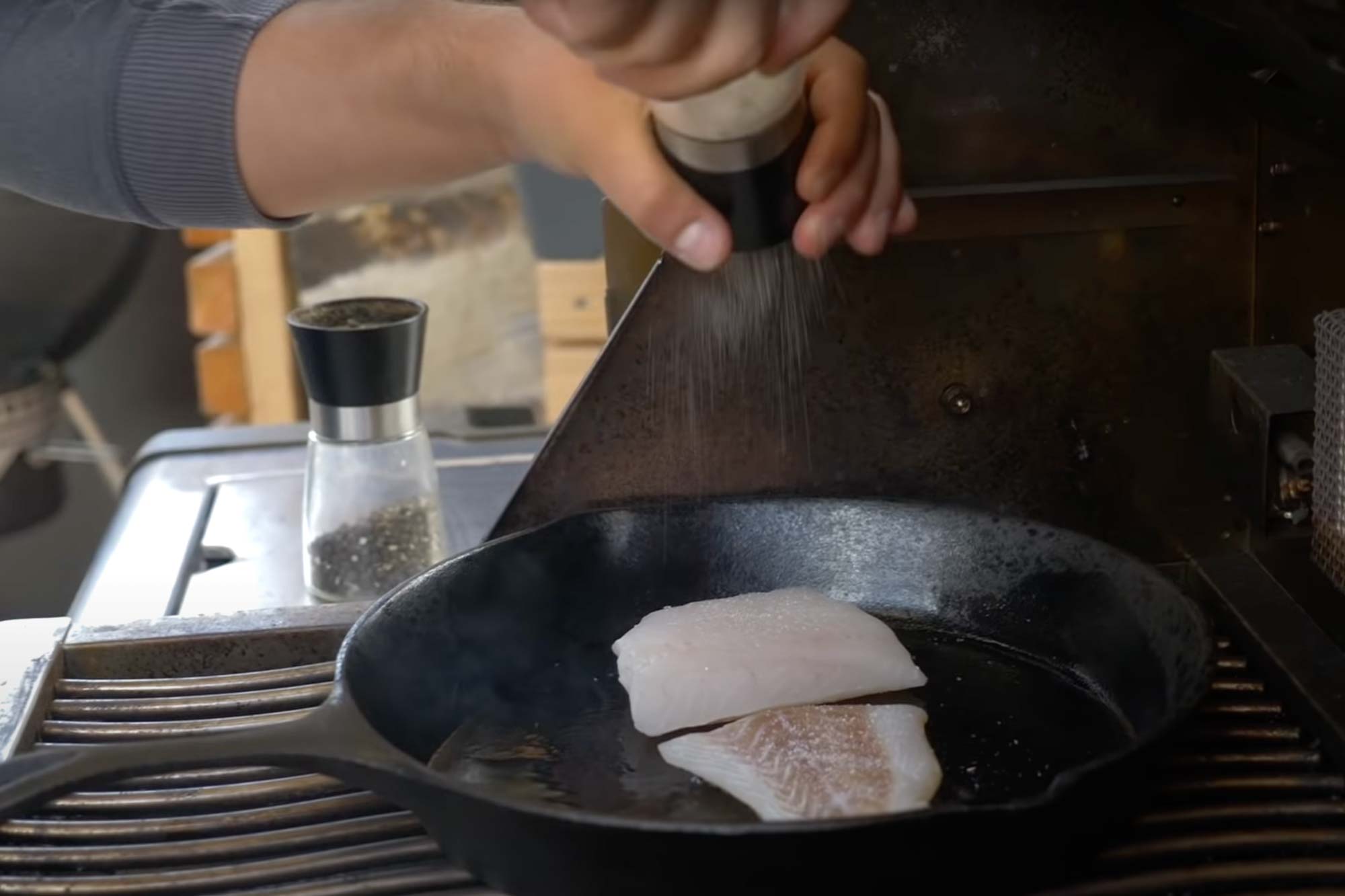 Fisch wird in der Pfanne gewürzt