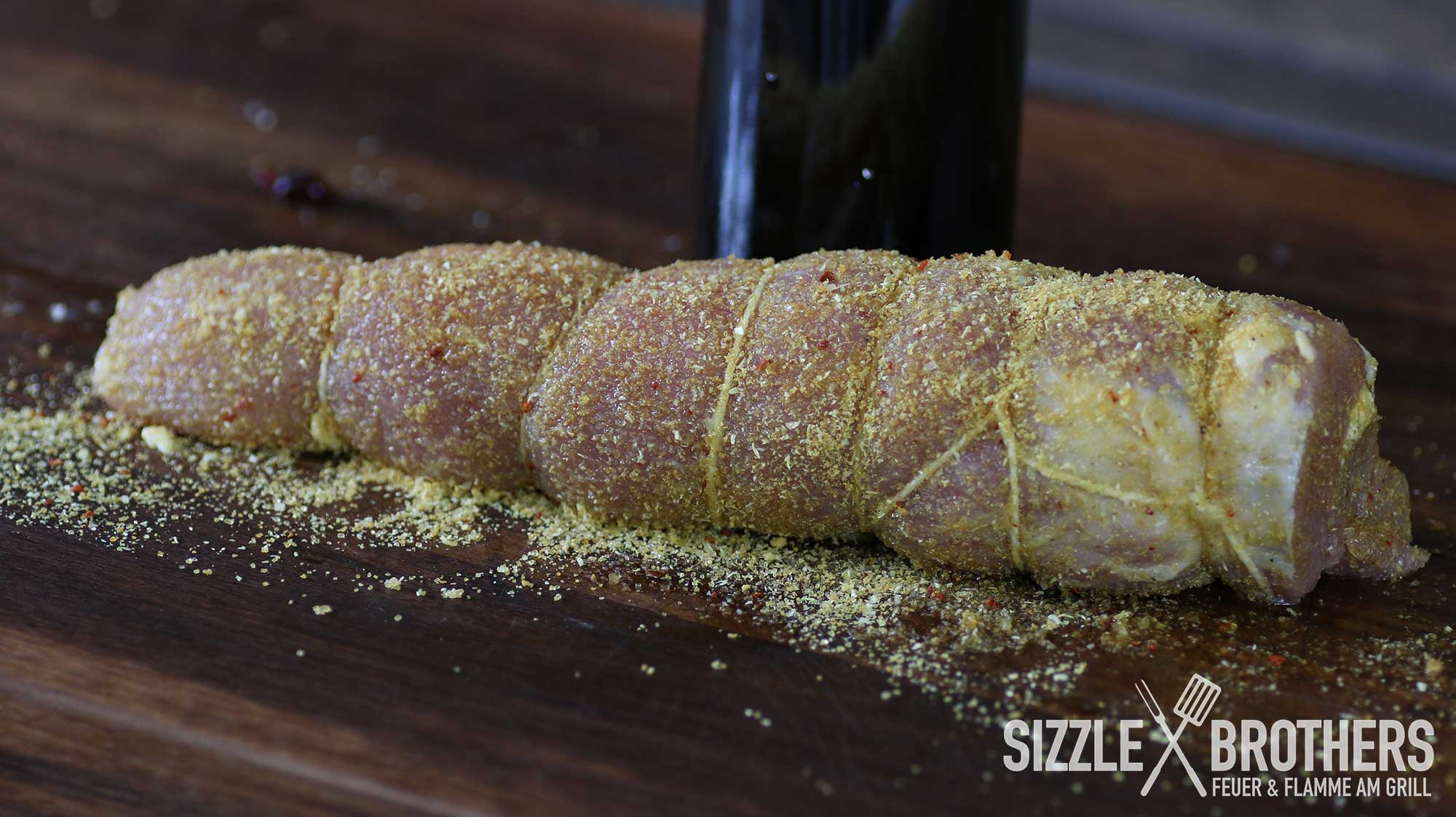 Mit Küchengarn fixiert, kann das gefüllte Schweinefilet nun auf den Grill