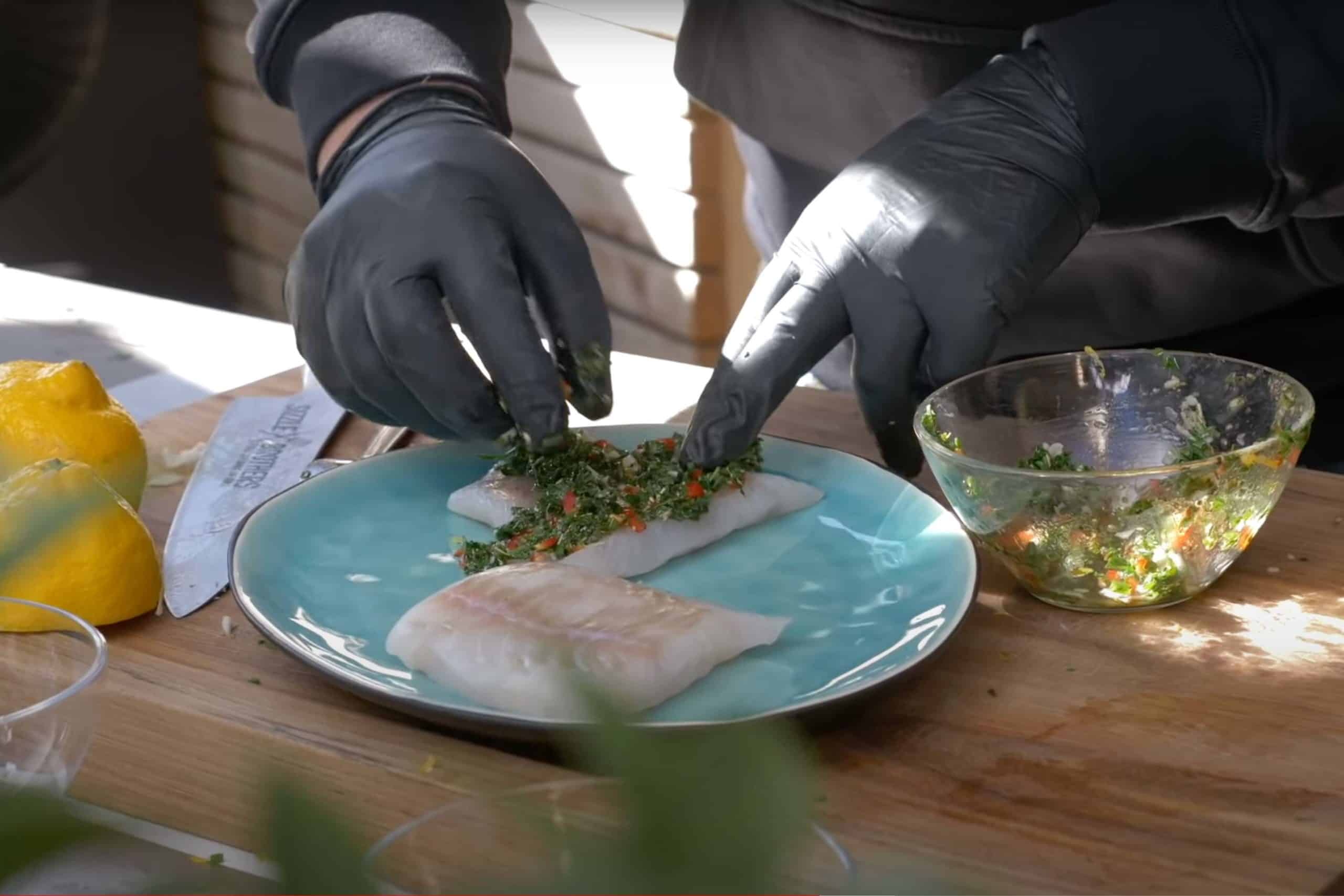 Fisch wird mit Kräutern belegt