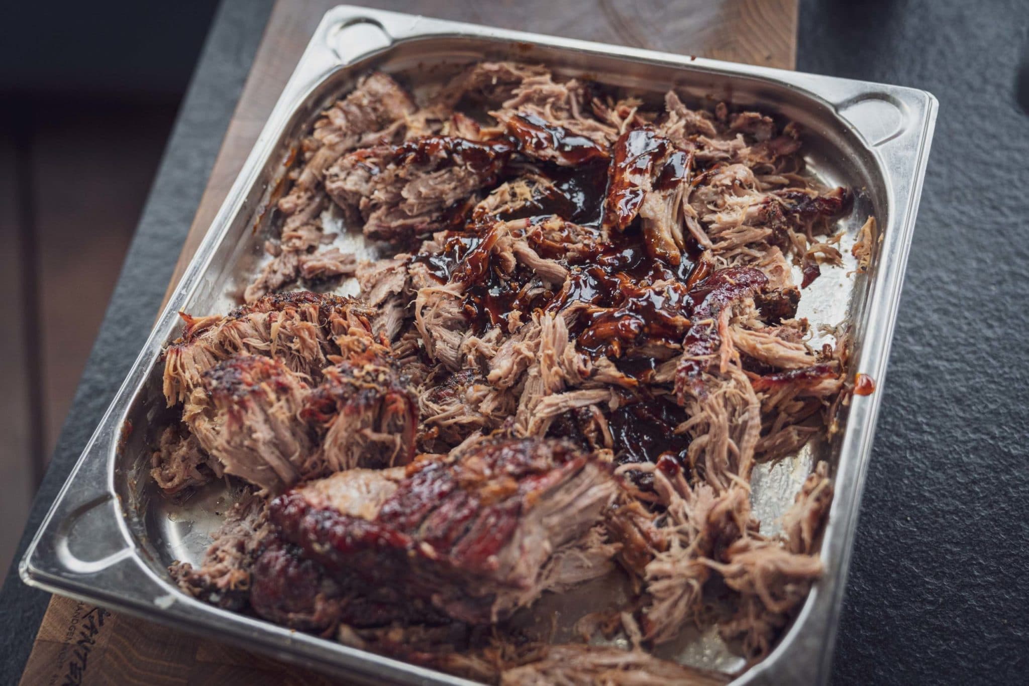 Zerzupftes Fleisch mit Barbecuesauce auf einem Tablett.
