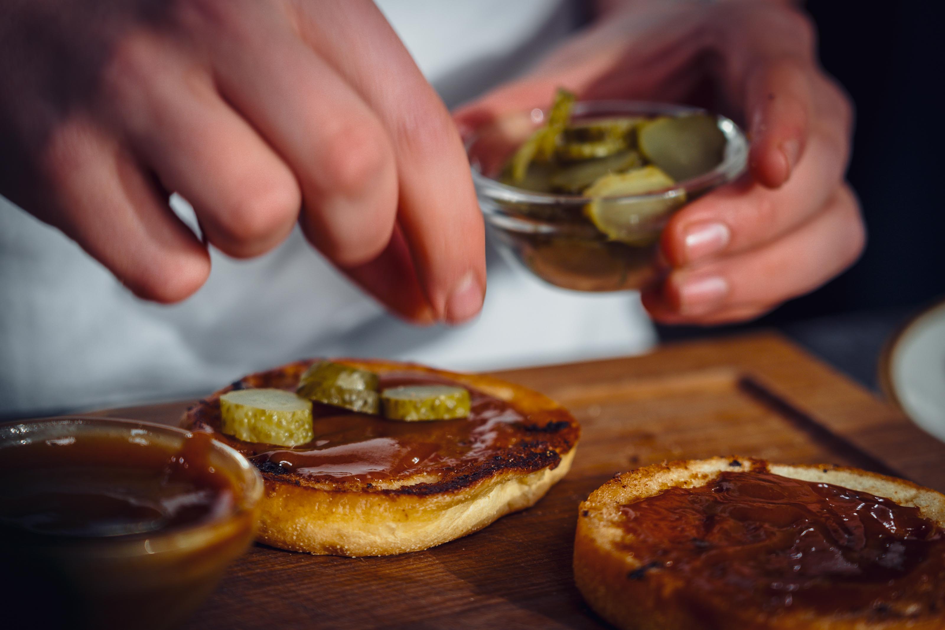 Gurken werden auf dem Burger platziert