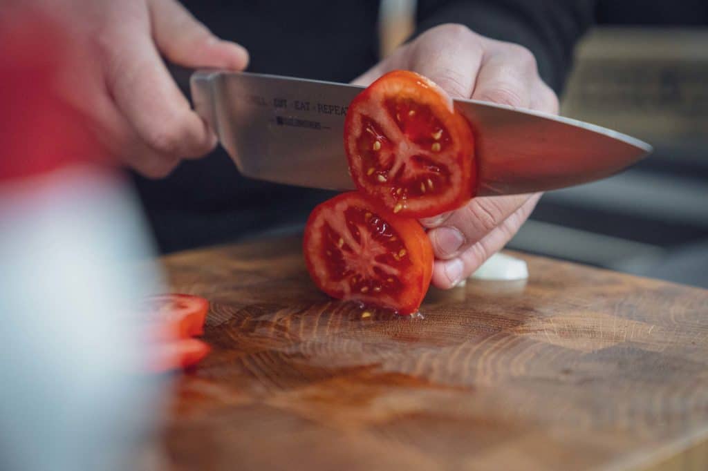 Tomaten werden mit dem Messer klein geschnitten