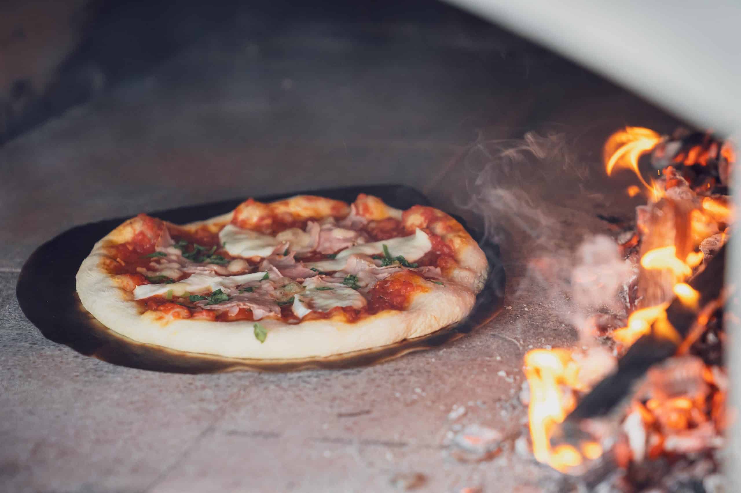 Die Pizza geht im Holzbackofen auf