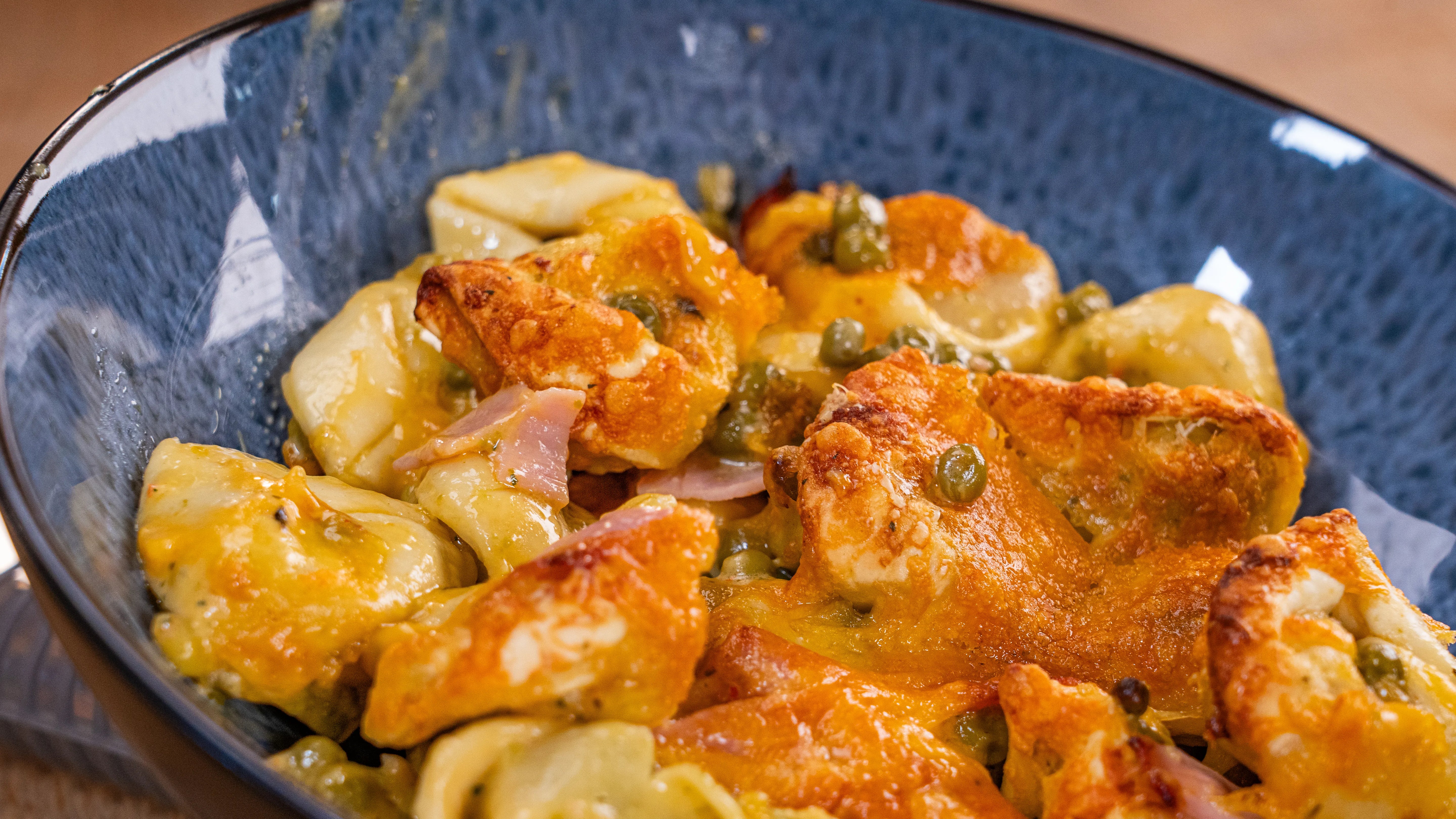 Gnocchi mit Röstzwiebeln und Kapern in einer blauen Schüssel.