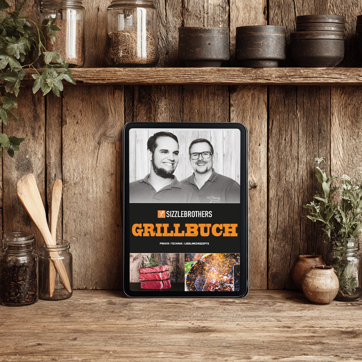 Ein Tablet mit einem Grillbuch vor einem Holzregal mit Küchenutensilien.