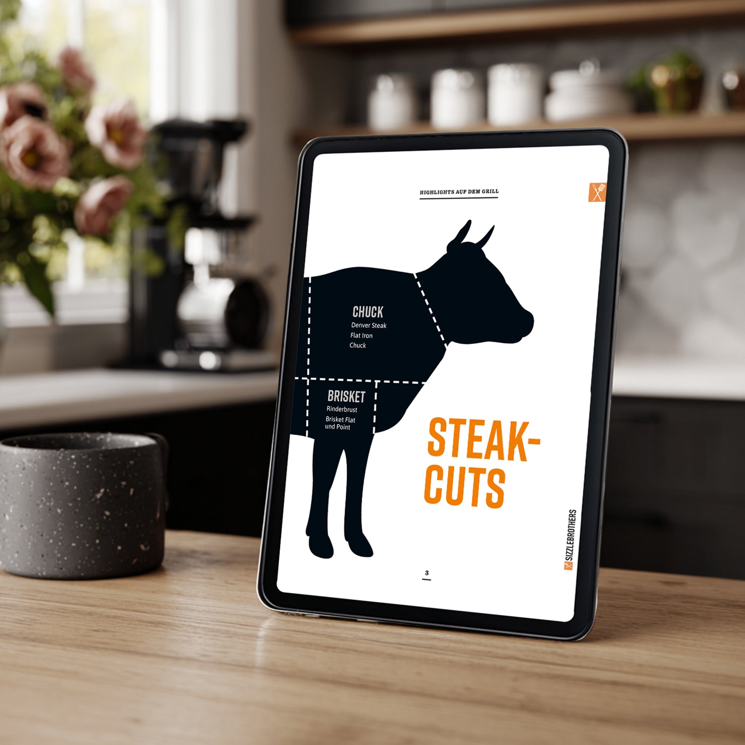 Tablet zeigt Silhouette eines Rinds mit Text 'Steak-Cuts' in einer Küche.