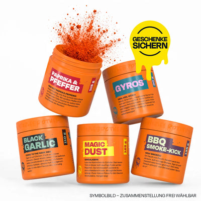 Fünf orangerote Gewürzdosen, eine mit sprühendem Paprika. Text: "Geschenke sichern".