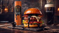 Saftiger Burger mit geschmolzenem Käse, Bacon, Salat und Tomate auf einem Brett daneben eine Flasche Guinness BBQ-Sauce und ein Glas Guinness-Bier