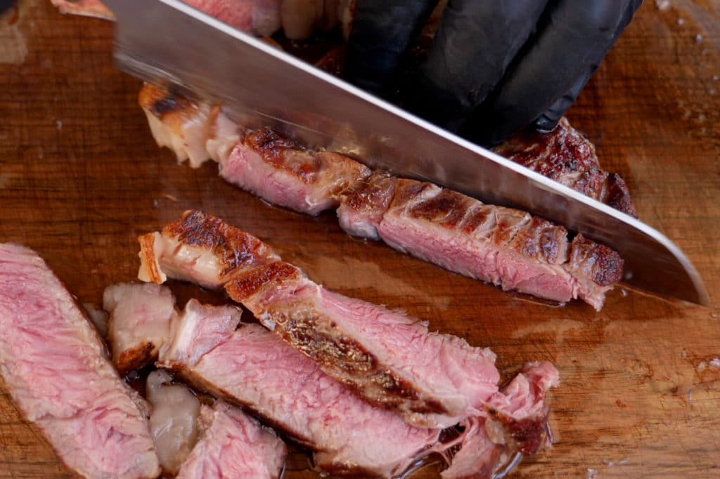 Ein Steak wird mit dem Messer angeschnitten