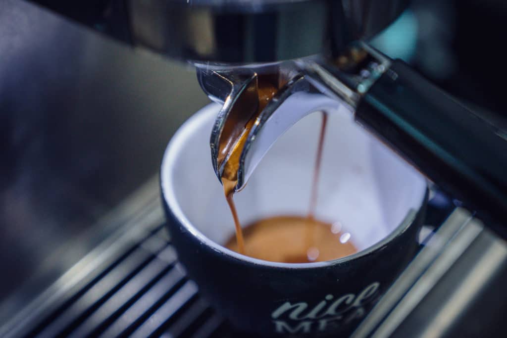 Der leckere Espresso läuft in die Tasse